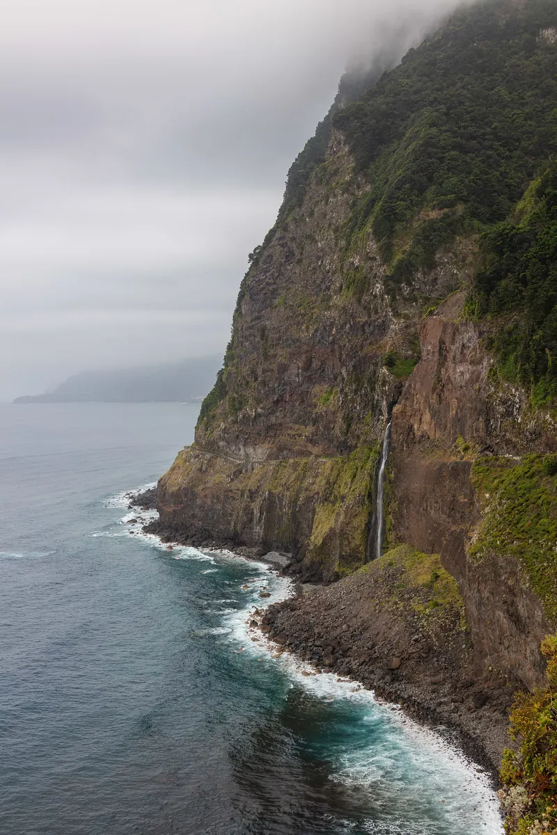 Seixal Waterfall — A waterfall that pours straight onto the coastal road.