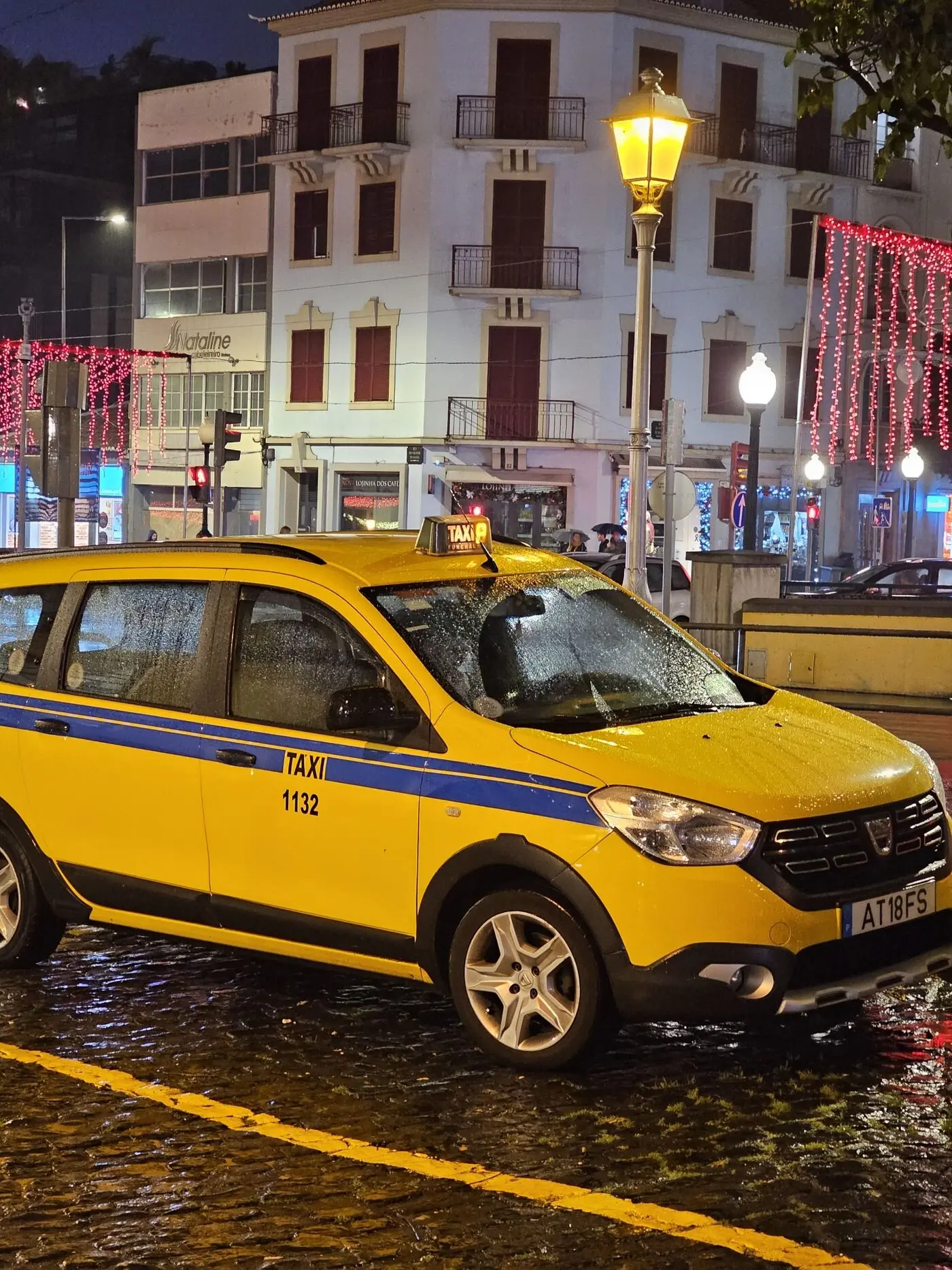 Funchal taxi on Madeira Island on a rainy night with Christmas lights